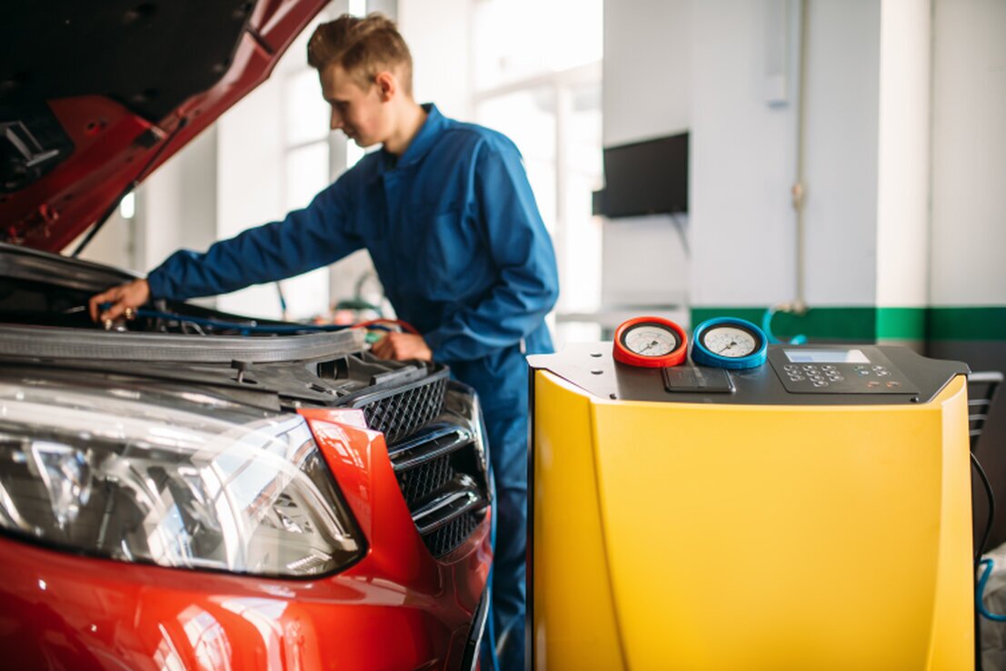 Mechaniker prüft die Klimaanlage im Auto